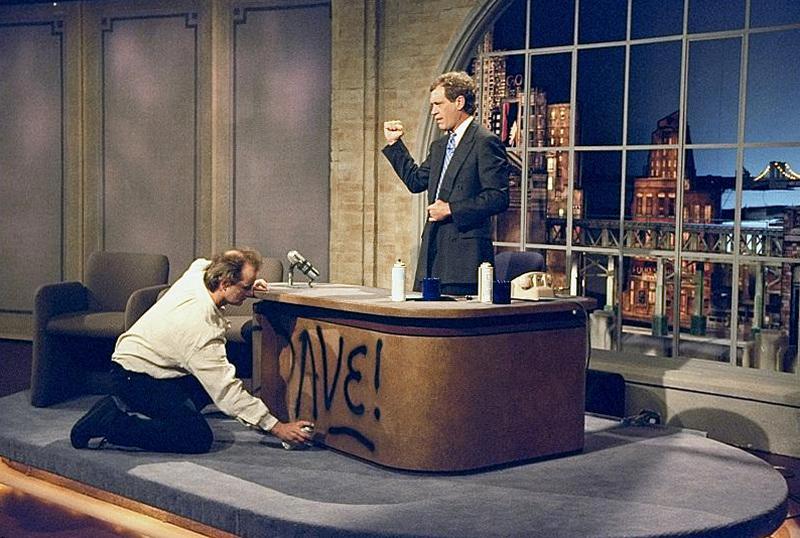 Билл Мюррей рисует баллончиком на столе Дэвида Леттермана во время съемок первого эпизода ​​"Вечернее шоу с Дэвидом Леттерманом", 1993 год
