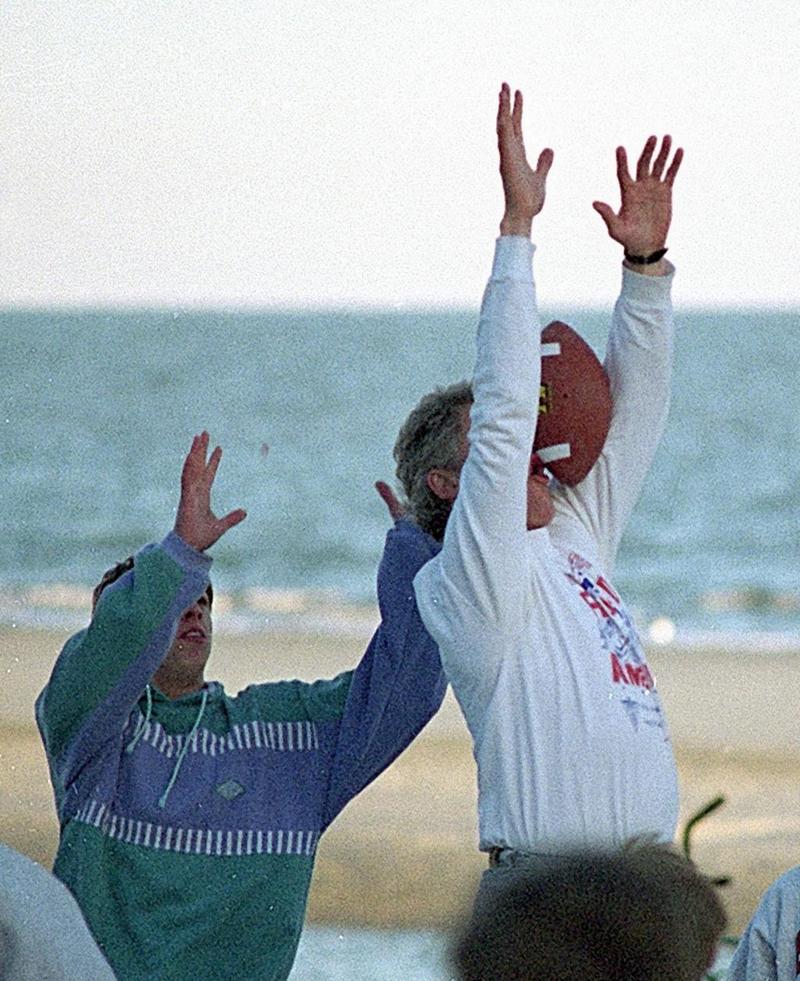 Президент Билл Клинтон не смог поймать мяч во время игры в американский футбол на пляже в отеле Hyatt Regency, 1993 год
