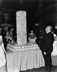 Альфред Хичкок празднует выход своего 50-о художественного фильма, "Разорванный занавес", с тортом в виде башни с надписями всех его фильмов.